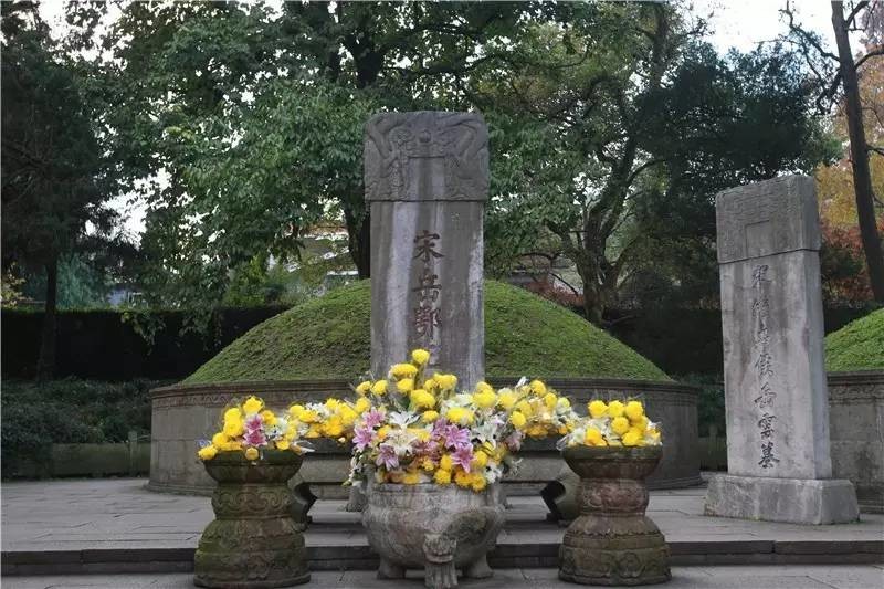 岳飞墓,墓碑前的供桌硕大,摆满了鲜花,从供桌上的痕迹看,经常有人祭拜