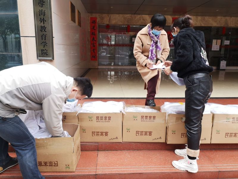 吕腮菊(中)与同事王琦老师(左)正在为来华留学生分发食物