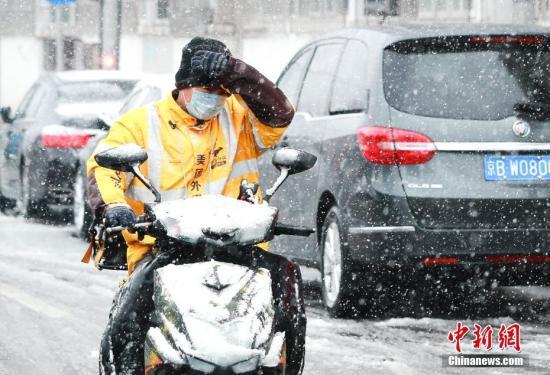 资料图：2月14日，外卖小哥在雪中送餐。当日，北京城区迎来鼠年以来的第三场降雪。