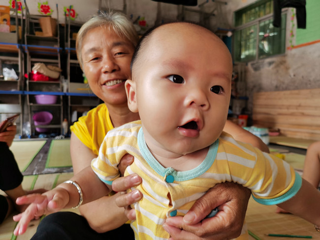 鄱阳县桂湖村57岁的曹桂花和她才4个月大的孙子。记者陶望平 摄