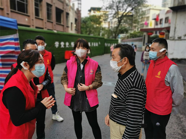 李萍和志愿者们戴着“精灵”耳朵在给群众解释防疫政策